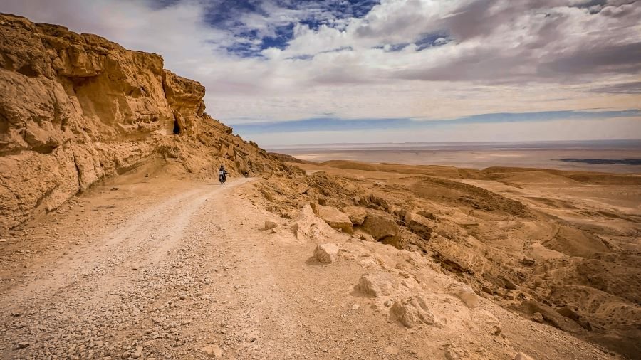 A rough road running along the side of a mountain in a desert region, Tunisia